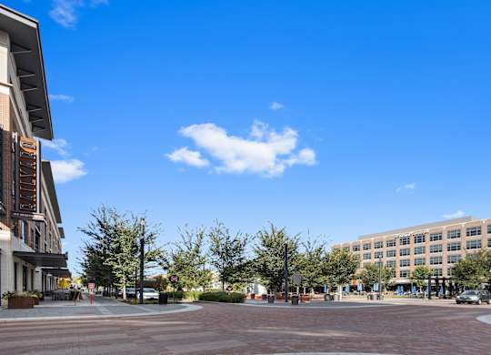 a city street with a building and a blue sky