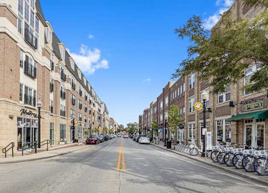 a city street with tall buildings and bicycles parked on the sidewalk