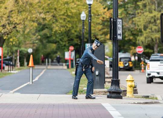 a police officer is standing on the curb of a street