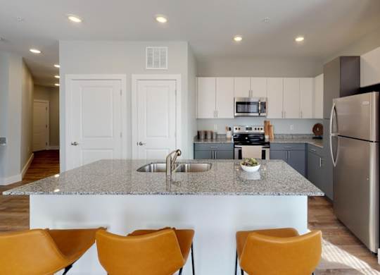 a kitchen with a granite counter top and a stainless steel refrigerator at Echo Park at Perry Crossing Apartments, Plainfield, Indiana