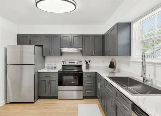 A modern kitchen with a stainless steel refrigerator and a range hood.
