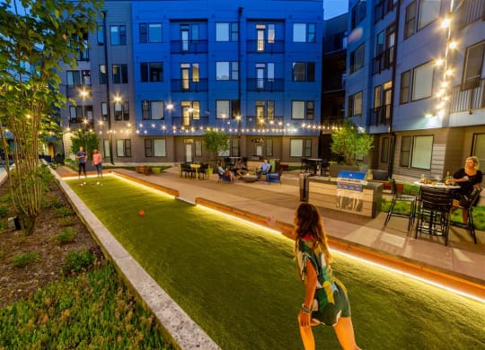 Outdoor pickle ball court with seating and lighting