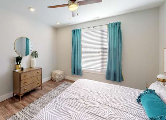 a bedroom with a bed and a ceiling fan at Echo Park at Perry Crossing Apartments, Indiana