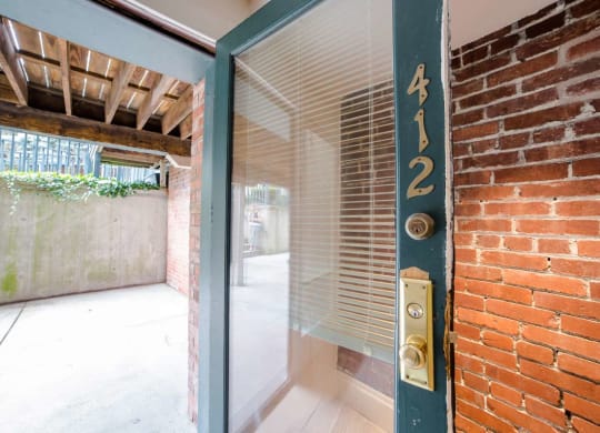 Outdoor Patio Space with Door view and exposed Brick inside at Lockerbie Court on Mass Ave, Indiana, 46204