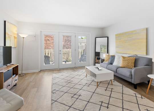 Modern living room at Monon Living in Broad Ripple featuring sleek furnishings, bright natural light, and direct access to a private patio near the Monon Trail.