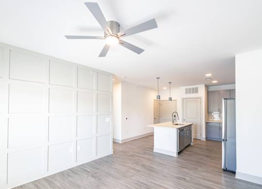 a white kitchen with a ceiling fan and a kitchen island