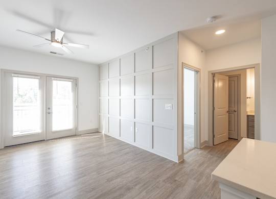 an empty living room with white walls and a ceiling fan