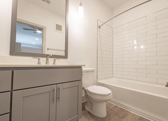 a bathroom with a toilet and a tub and a sink