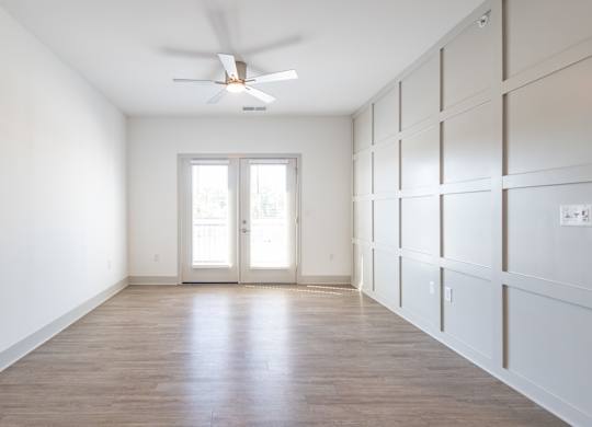 an empty room with white walls and a ceiling fan