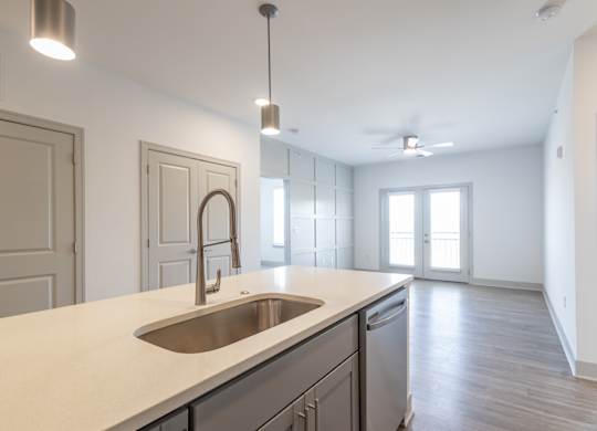 an empty kitchen with a sink and an empty living room