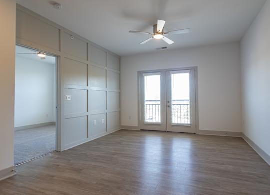 an empty room with white walls and a ceiling fan