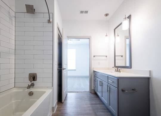 a bathroom with a tub and a sink and a mirror
