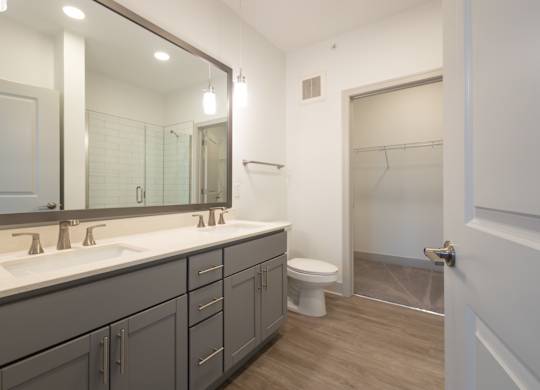 a bathroom with a large mirror and a toilet and a shower