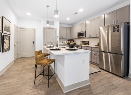 a kitchen with a large island and stainless steel appliances