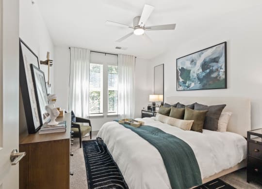 a bedroom with a large bed and a ceiling fan