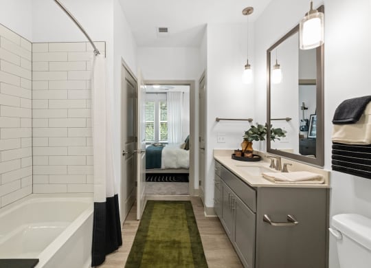 a white bathroom with a tub and a sink and a mirror