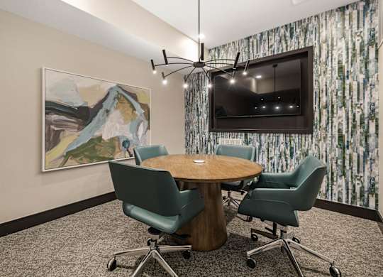 a conference room with a table and chairs and a television