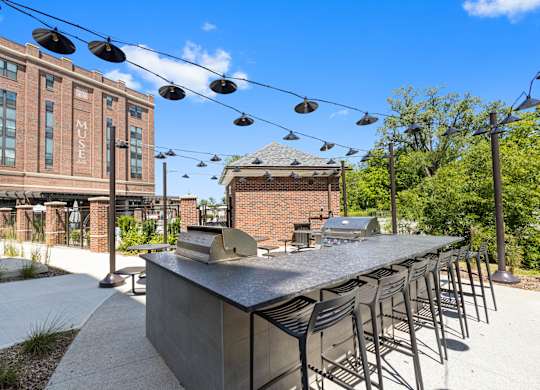 a communal bar with chairs and a building in the background