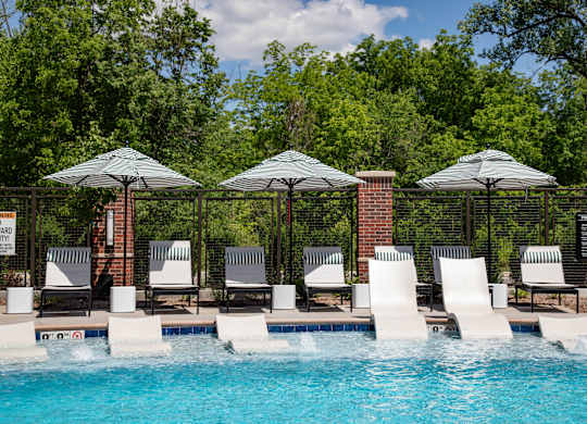 a swimming pool with chairs and umbrellas next to it