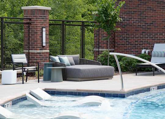 a swimming pool with a couch and chairs next to a pool