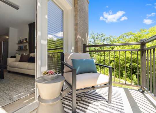 a patio with a chair and a table on a balcony