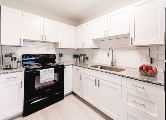 a kitchen with a black stove top oven next to a sink