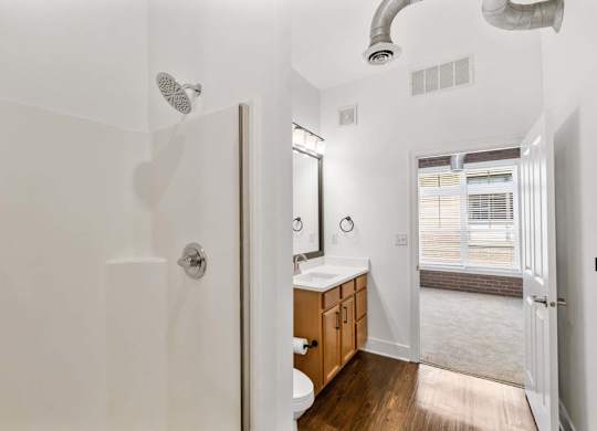 A bathroom with a walk in shower and a toilet.at The Foundry, South Bend Indiana