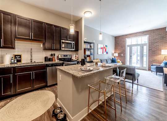 a kitchen with a bar and a living room at The Foundry, South Bend, IN