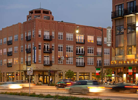 a large brick building on a city street with traffic at The Foundry, South Bend, IN 46617