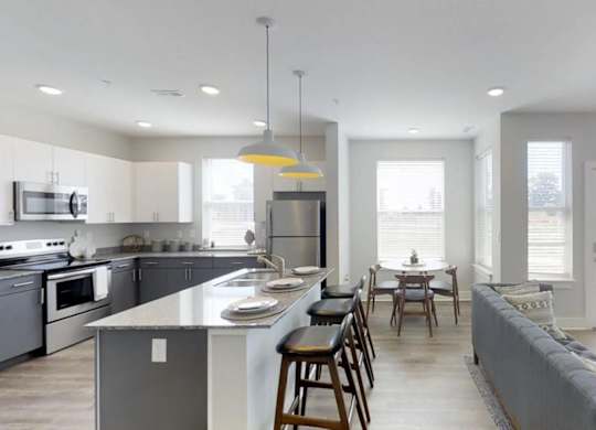 an open kitchen and living room with a table and chairs at Echo Park at Perry Crossing Apartments, Plainfield, Indiana