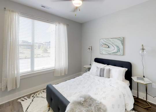 a bedroom with a bed and a large window at Echo Park at Perry Crossing Apartments, Plainfield, IN, 46168
