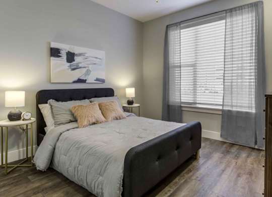 a bedroom with a bed and a large window at Echo Park at Perry Crossing Apartments, Plainfield, Indiana