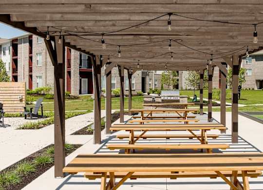 a row of picnic tables under a covered pavilion at Echo Park at Perry Crossing Apartments, Indiana