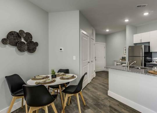 a kitchen with a table and chairs next to a counter top at Echo Park at Perry Crossing Apartments, Plainfield