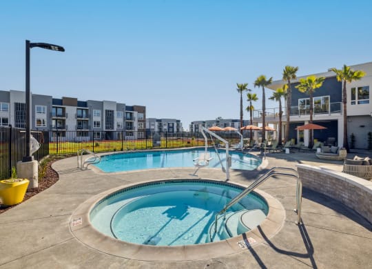 a hot tub and pool with a building in the background