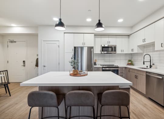 an open kitchen with a large white island with four chairs at 38° NORTH, California