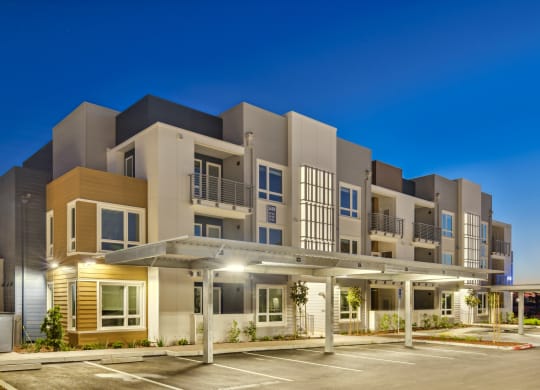 a modern apartment building with a parking lot at night at 38° NORTH, Santa Rosa, CA 95404