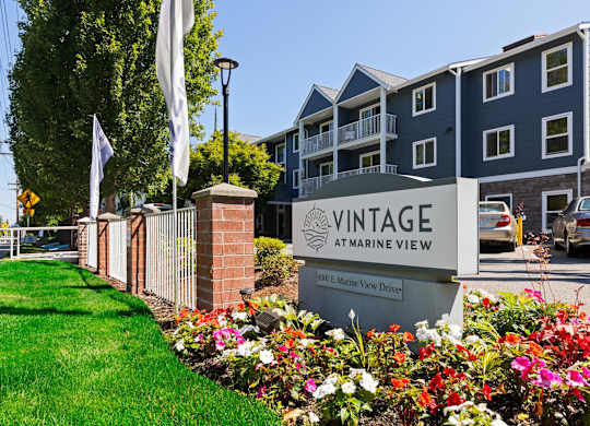 A sign for Vintage at Marine View stands in front of a building.