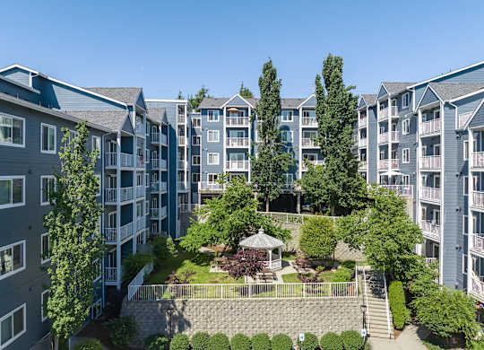 Apartment complex with a courtyard and trees.