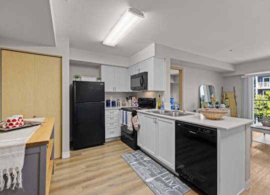 A modern kitchen with black appliances and wooden cabinets.