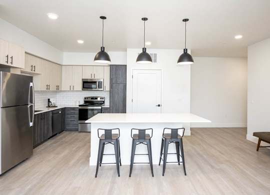 A kitchen with a white island and black bar stools. at 38° NORTH, Santa Rosa, California