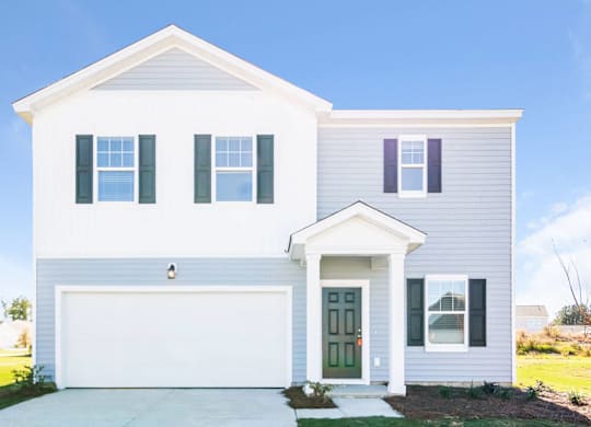 a white house with blue shutters and a driveway