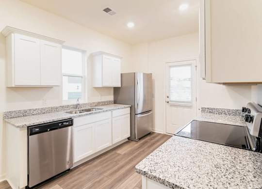 a kitchen with granite counter tops and stainless steel appliances