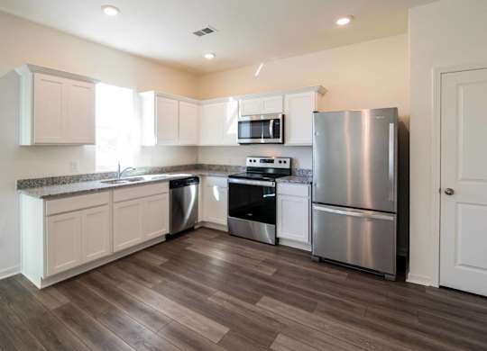 a kitchen with stainless steel appliances and white cabinets
