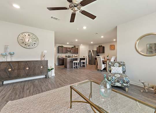 Open-concept living and kitchen area with wood floors, neutral walls, and stylish decor.