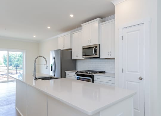 Pet Friendly Townhomes in Lower South End NC - Loso Walk - Modern Kitchen with a Kitchen Island, Stainless Steel Appliances, and White Cabinetry