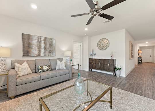 Living room with gray sofa, glass coffee table, and decorative accents.