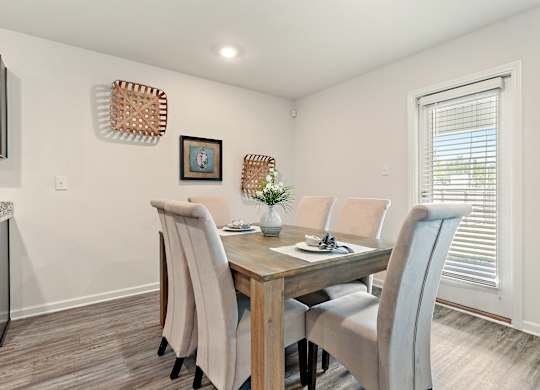 Dining room with wooden table, six upholstered chairs, and decorative wall baskets.