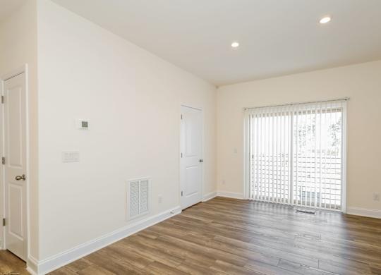 a bedroom with hardwood floors and white walls