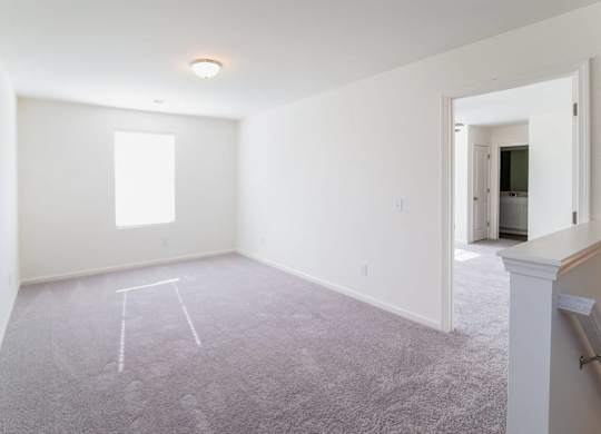 an empty living room with white walls and a window